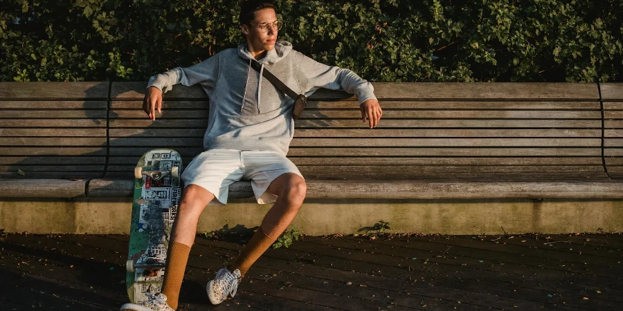 young male skater sitting on wooden bench