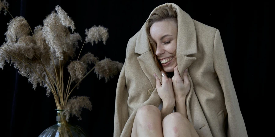 A woman in a coat sitting on a chair