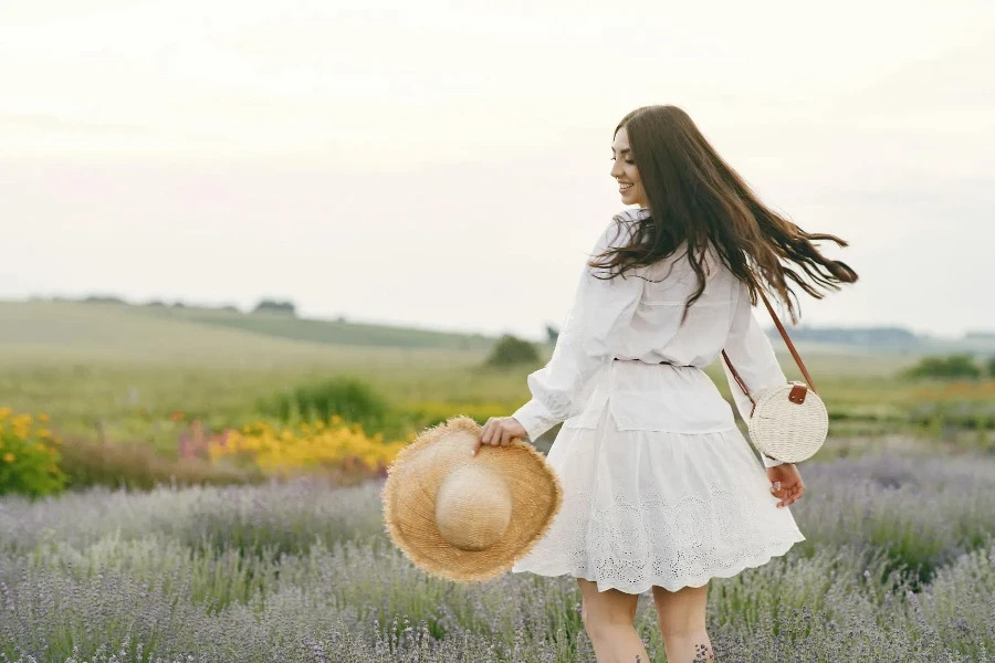 A Woman in White Holding a Sun Hat