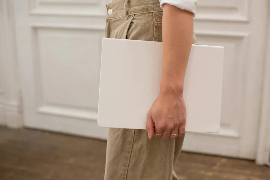 female in stylish jeans with white blank notebook