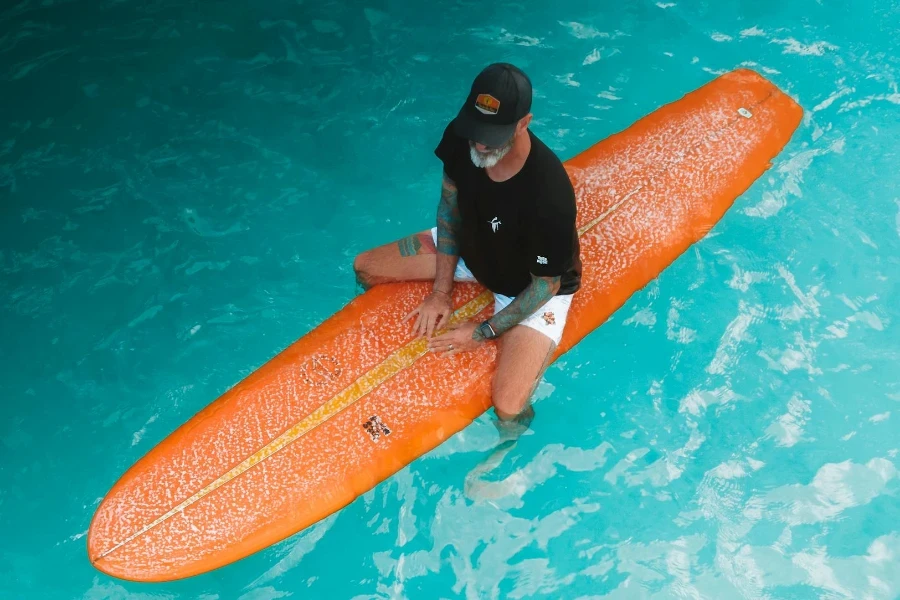 Top View of Man on Surfboard in Blue Water