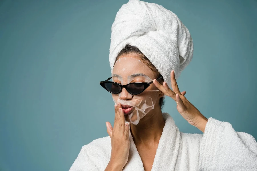 Calm African American woman with moisturizing sheet mask