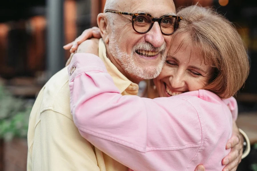 Man in Yellow Shirt and Eyeglasses Hugging Woman