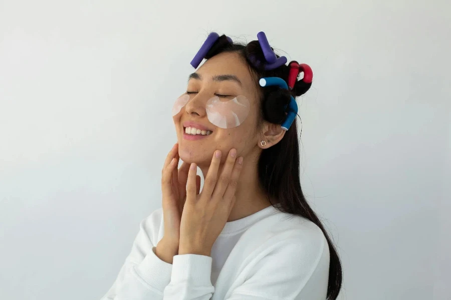 Smiling young ethnic female with hair rollers