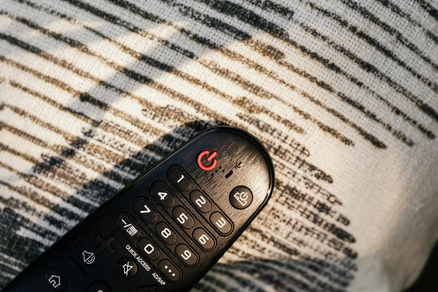 Black Remote Control on Black and White Knitted Fabric