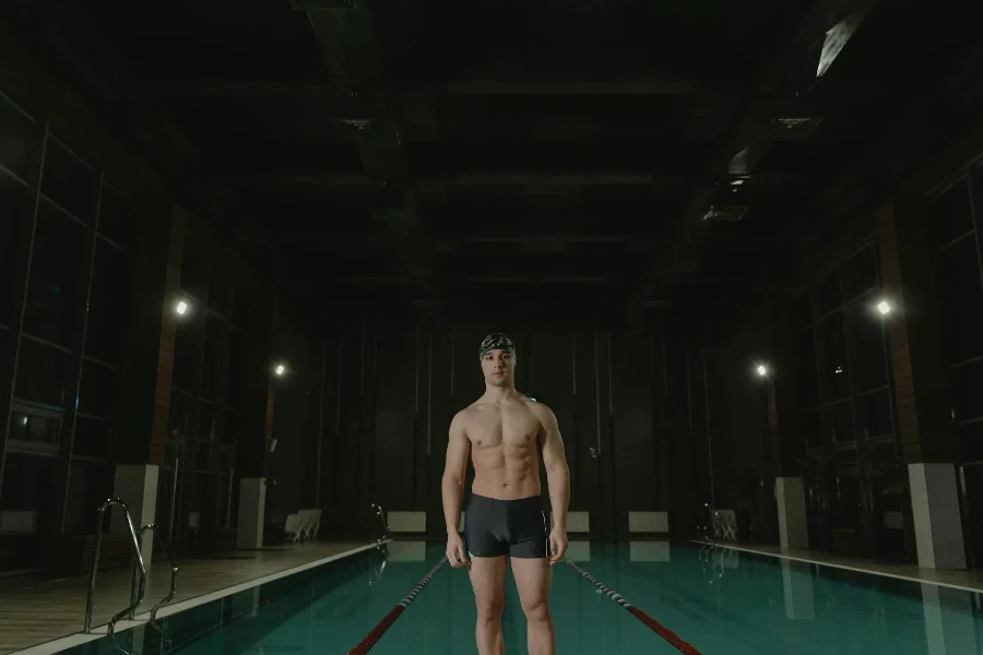 Shirtless Man Standing at the Poolside