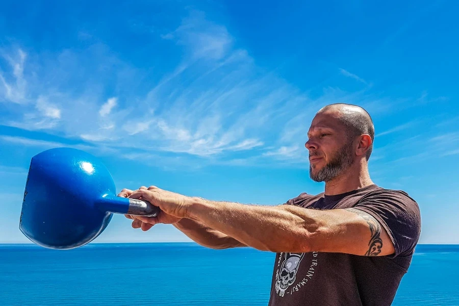 Man Wearing Black Shirt Holding Kettle Bell