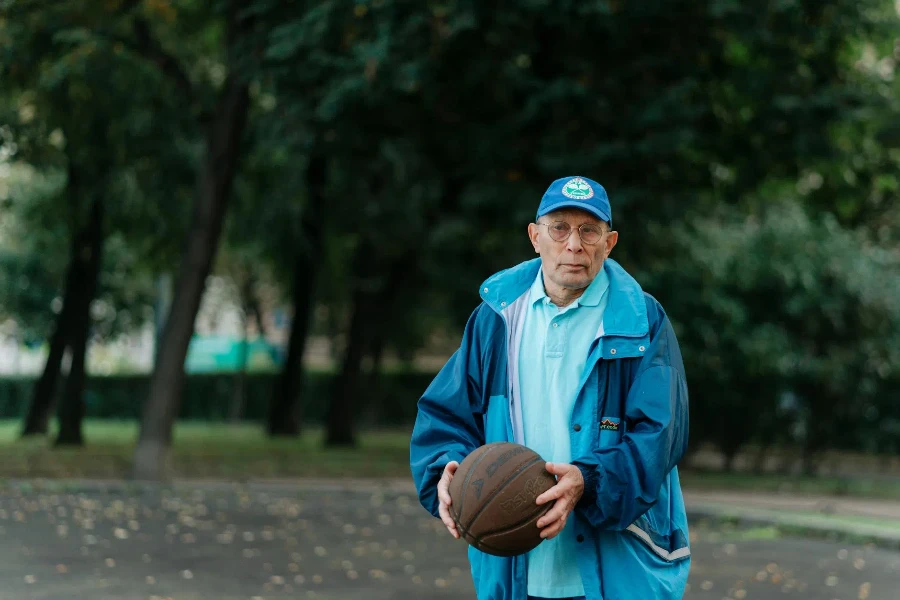Adult Man in Blue Jacket Holding a Ball