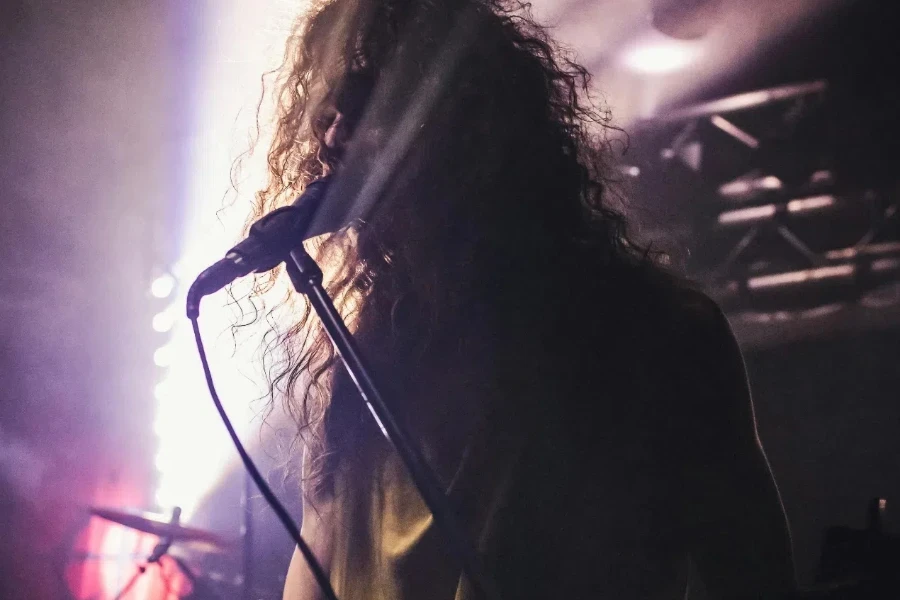 A man with long hair playing guitar in a concert