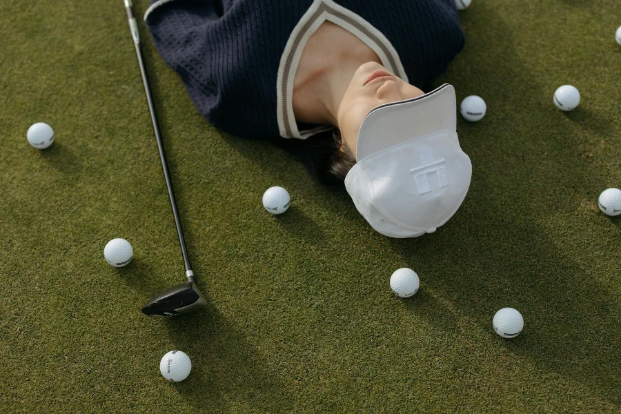 Woman Wearing a White Cap Lying on the Ground