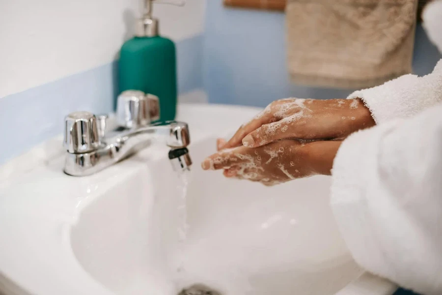 Black woman washing hands in bathroom