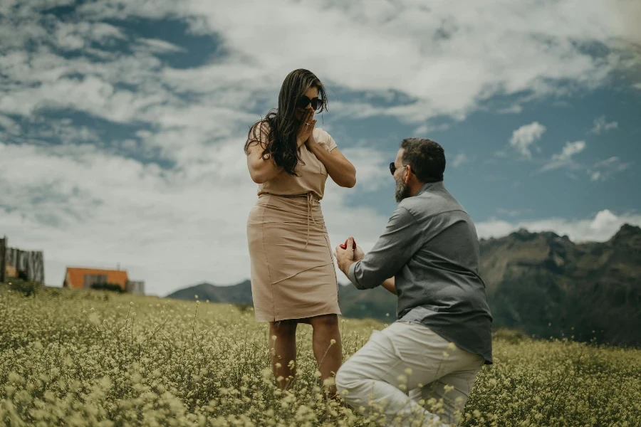 A man proposing to a woman in a field