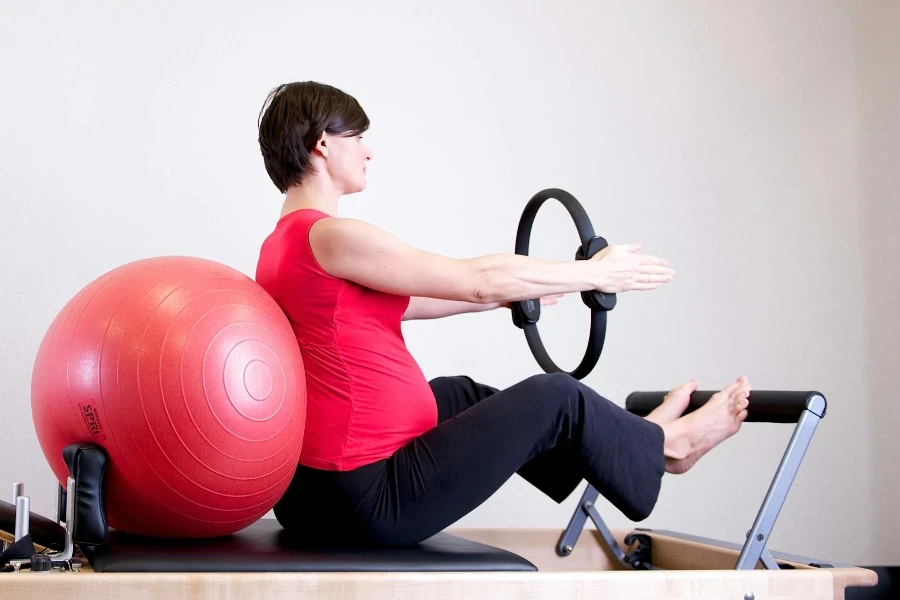 Woman in Red Shirt Sitting on Fitness Equipment