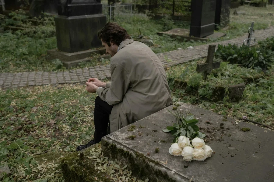 A Man Sitting by a Grave