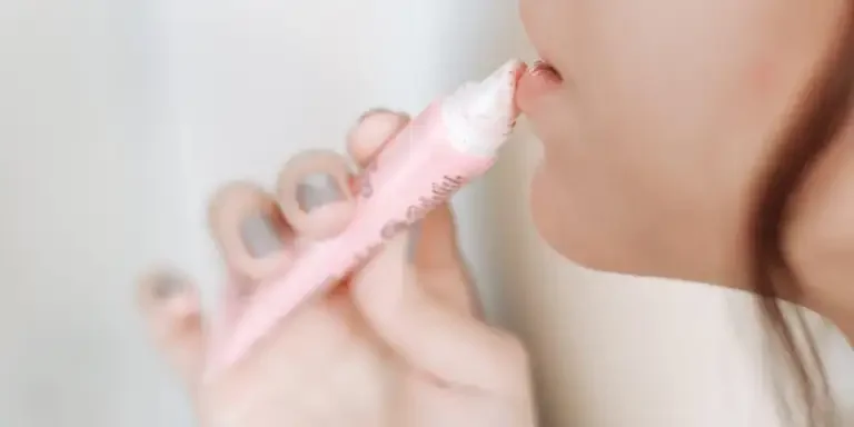 Lady applying lip product from a tube