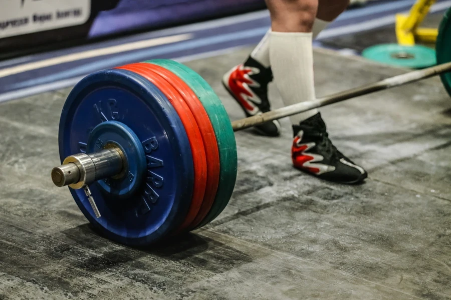 legs male athlete powerlifter and barbell lying on platform, starting deadlift in powerlifting competition