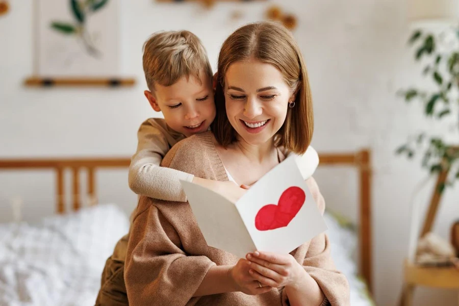 little boy son congratulating his mom happy woman with Mothers day