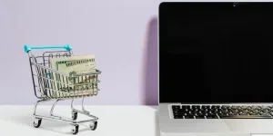 Miniature of a shopping trolley beside a laptop