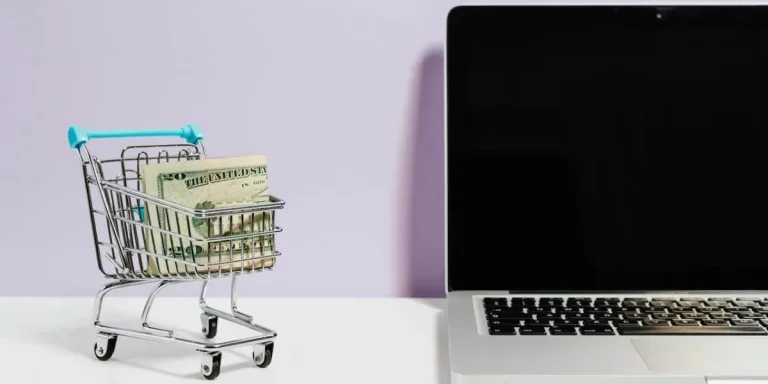 Miniature of a shopping trolley beside a laptop