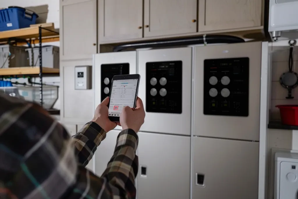 n the garage, there is an energy storage system on top of three large industrial beige stacks with black tops and white walls in front of them