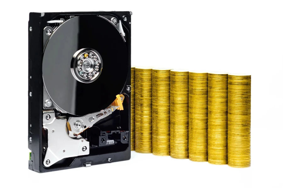 naked harddisk show internal disc with reflections on white background with stacked coins in business growing shape represent about e-business, blockchain and cryptocurrency with clipping path