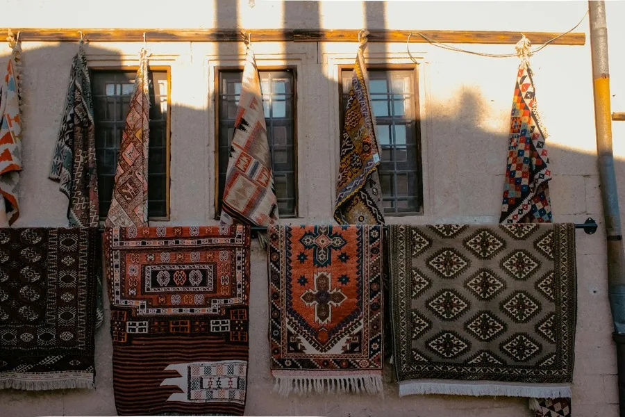 Patterned rugs hanging on a building wall