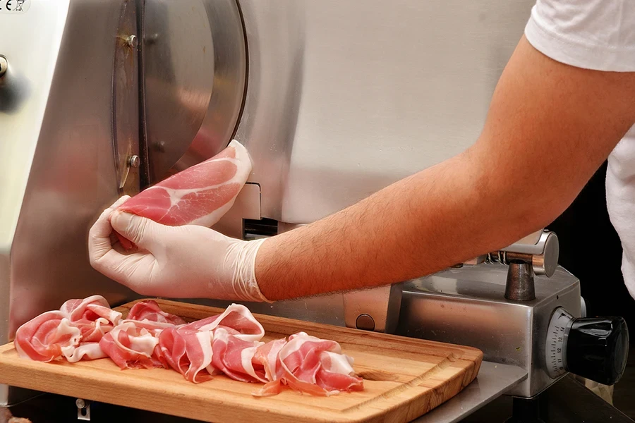 slicing prosciuto ham with industrial slicer machine