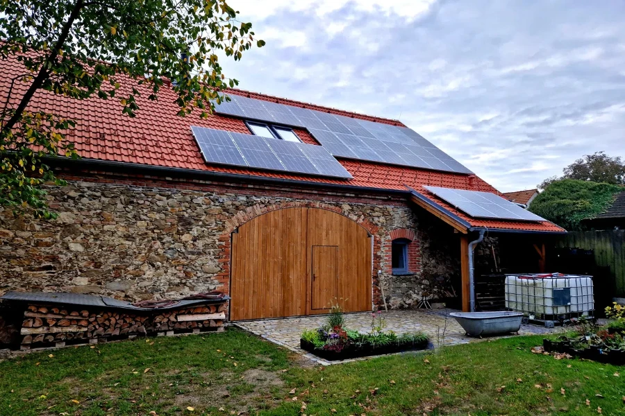 the stone barn has a roof covered with solar panels