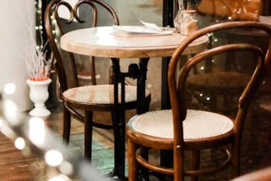 Two-seater round metal dining table and wooden chairs