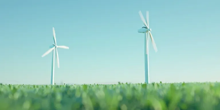 two white wind turbines against the blue sky