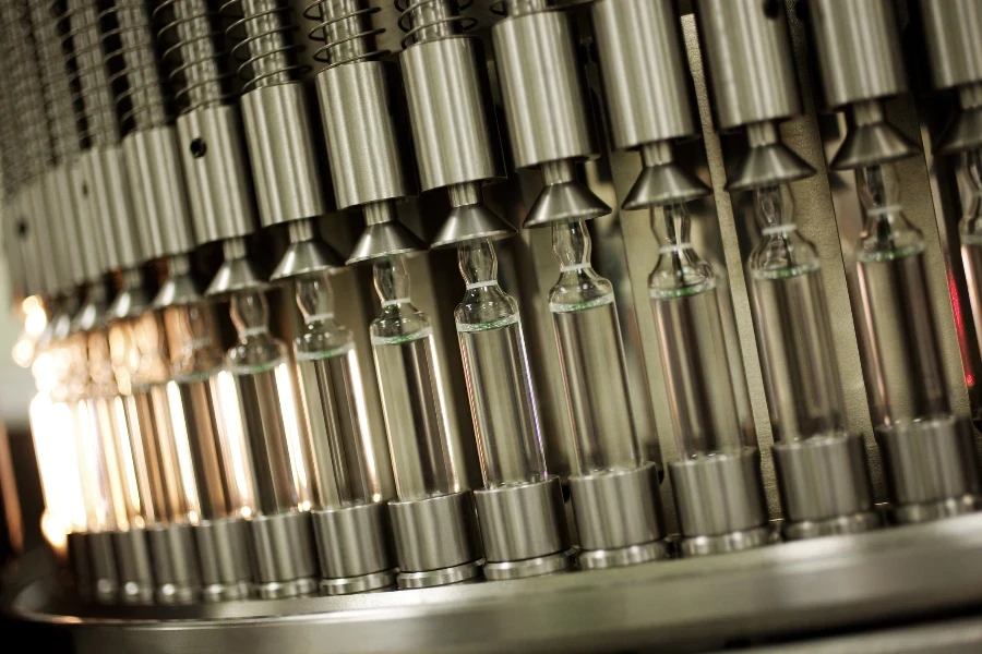 vaccines in glass vials being prepared for packing in a pharmaceutical company