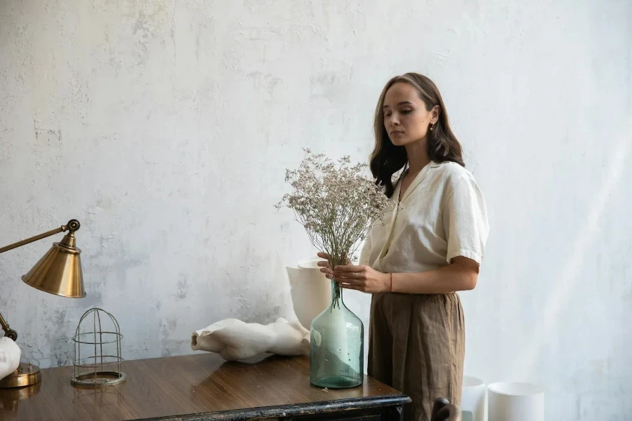 Woman placing flowers in a glass vase