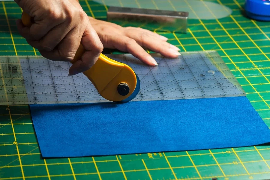 woman's hands using rotary cutter for her patchwork