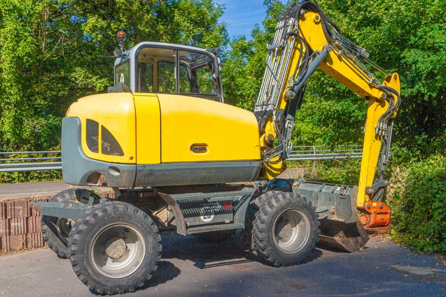 yellow gray wheel loader with excavator shovel at the edge of a construction site