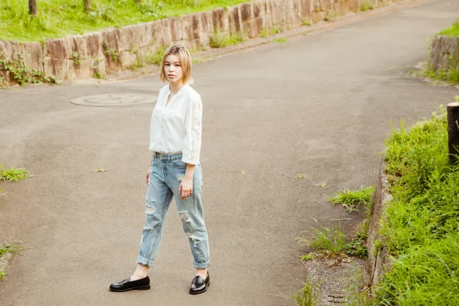 Young woman wearing high-waisted baggy jeans and polished loafers