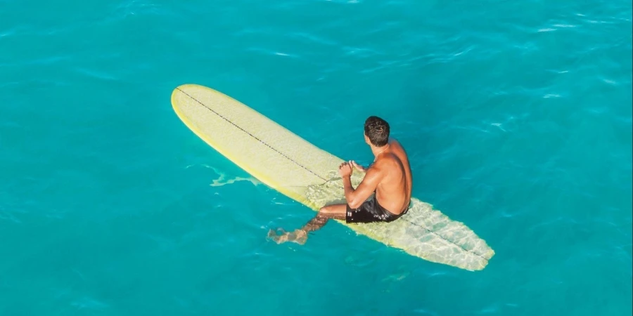 A Man Sitting on the Surfboard