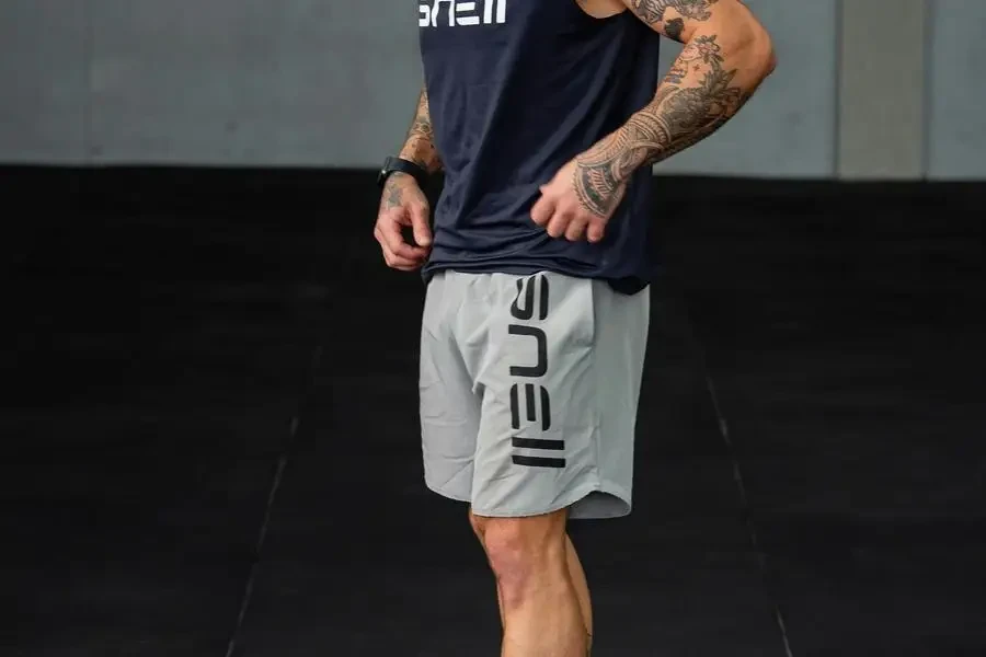 A Tattooed, Muscular Man in Sportswear Standing at the Gym by Giovanni Caprio