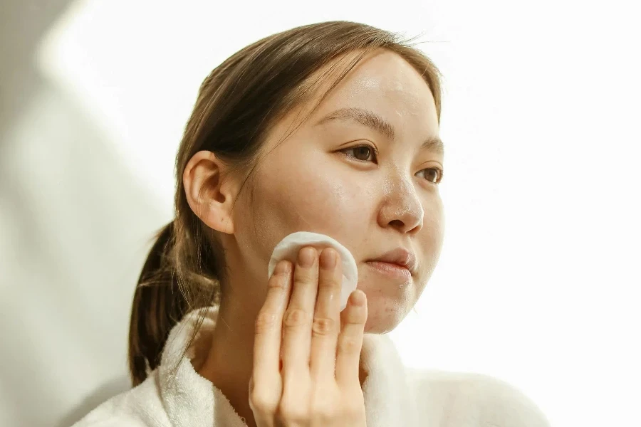 A Woman Wiping Her Face with a Cotton Pad