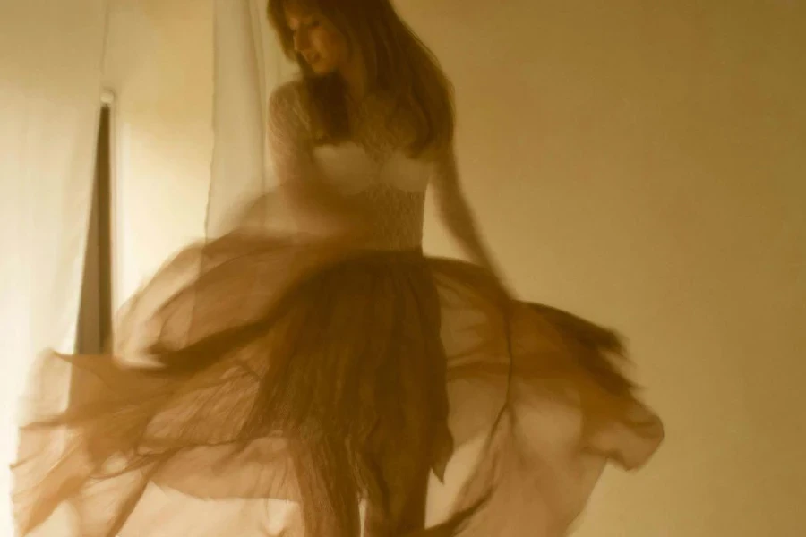 A Woman in a Tulle Dress Jumping on a Bed