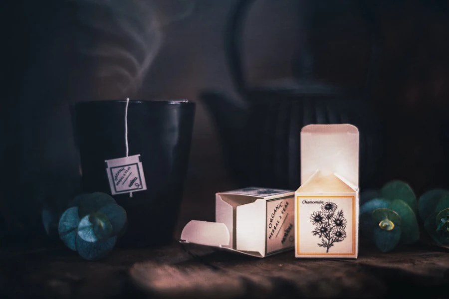 A black mug with tea bag and some tea boxes