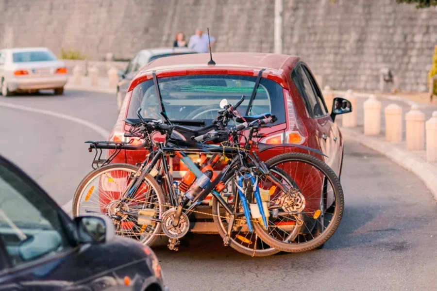 A car loaded with bicycles rides along the road