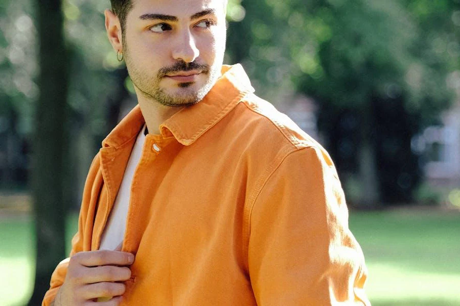 A man looking sideways in an orange overshirt