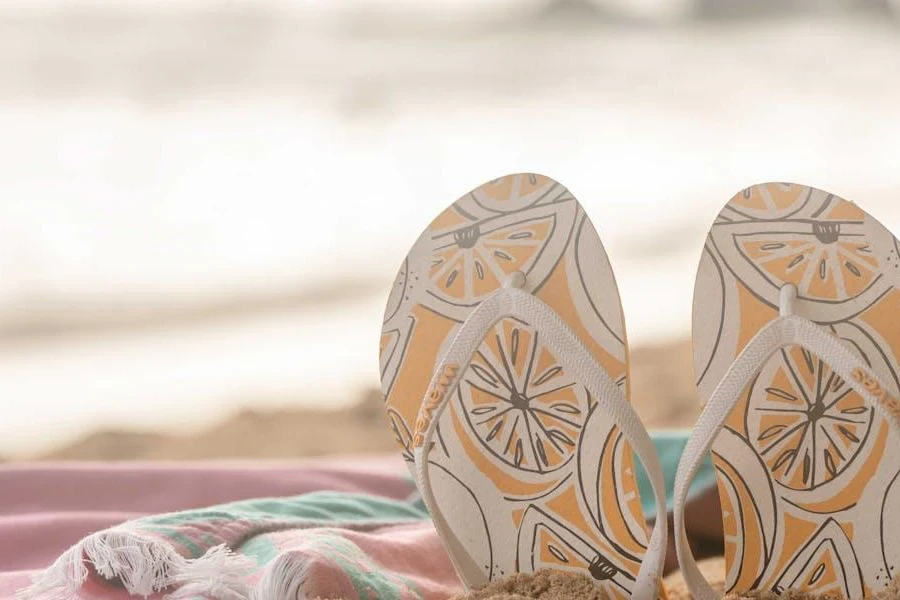 A pair of cool-girl flip-flops poking out from the sand