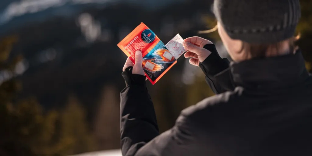 A person holding a packet of hand warmers