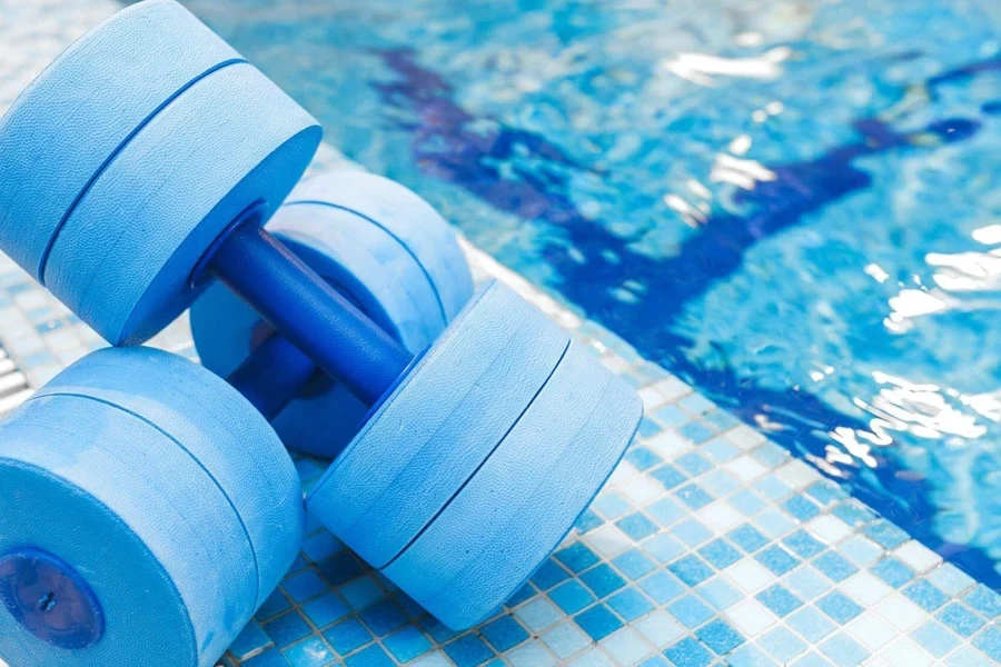 A set of aqua dumbbells near a pool