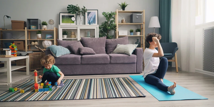 A woman and child are doing yoga in a living room