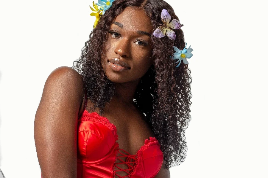 A woman in a red top and jeans holding flowers