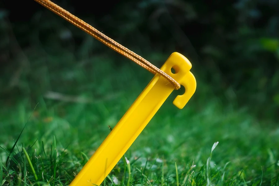 A yellow plastic peg pitched on grass