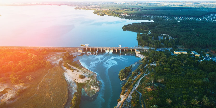 Aerial view of Dam at reservoir with flowing water at sunset