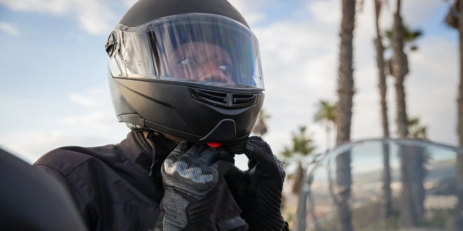 An African biker wears a helmet while sitting on his motorcycle, road safety.